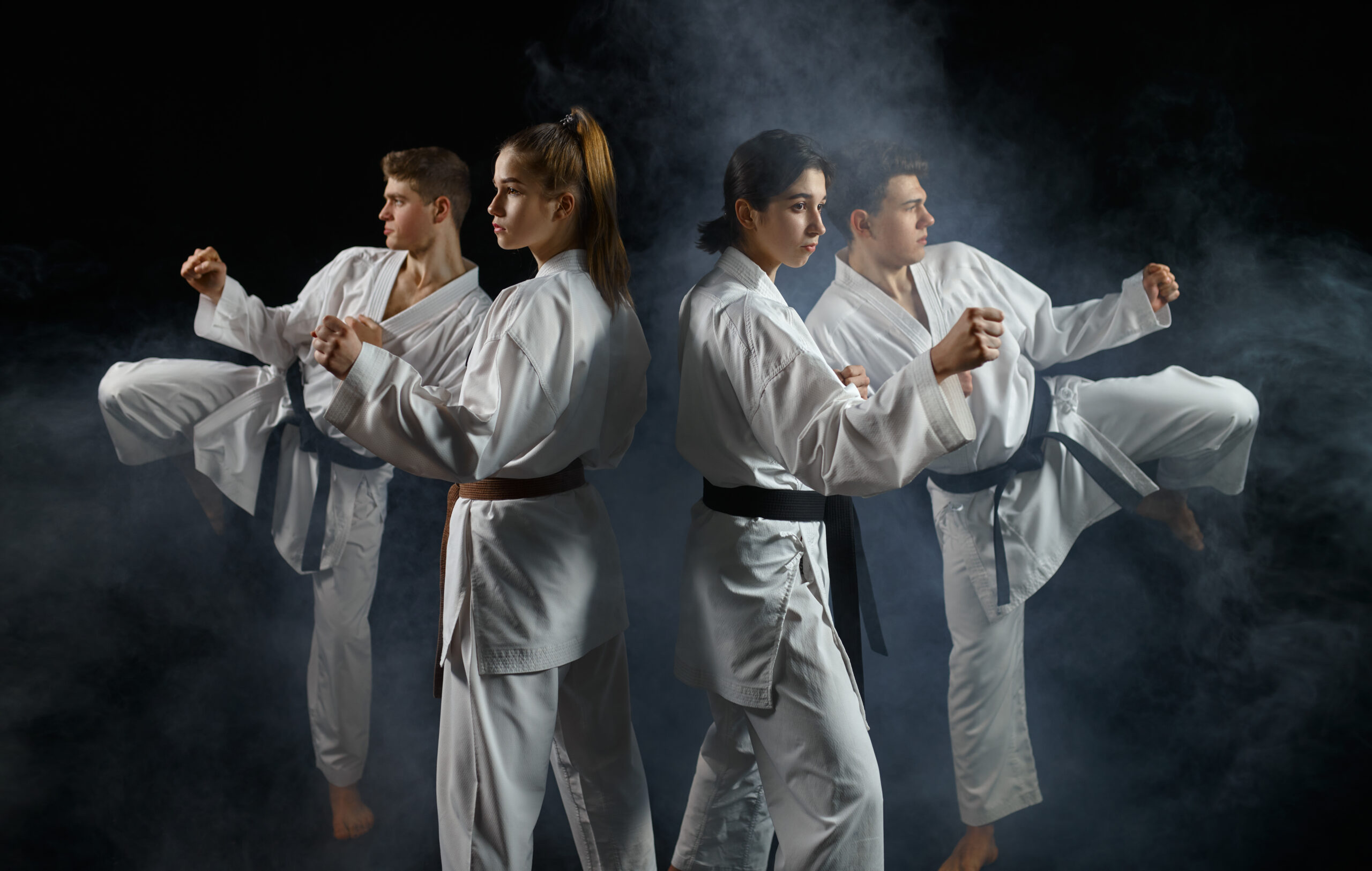 Four karate fighters in kimono, smoky background